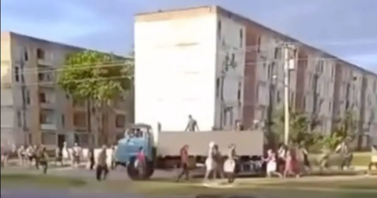 Cubanos corren detrás de un camión de arroz.
